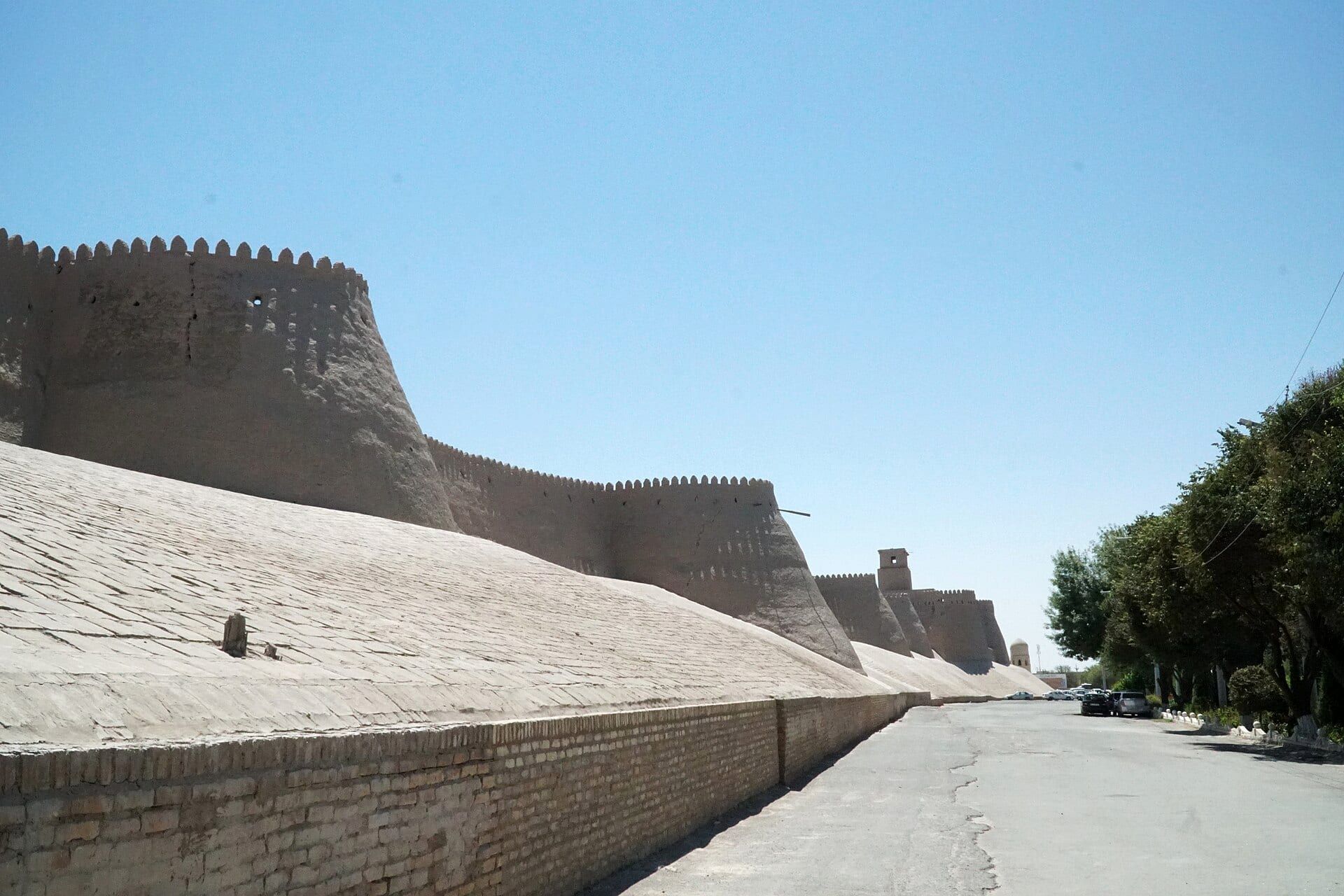 The mud-brick walls of Itchan Kala in Khiva under a clear sky.